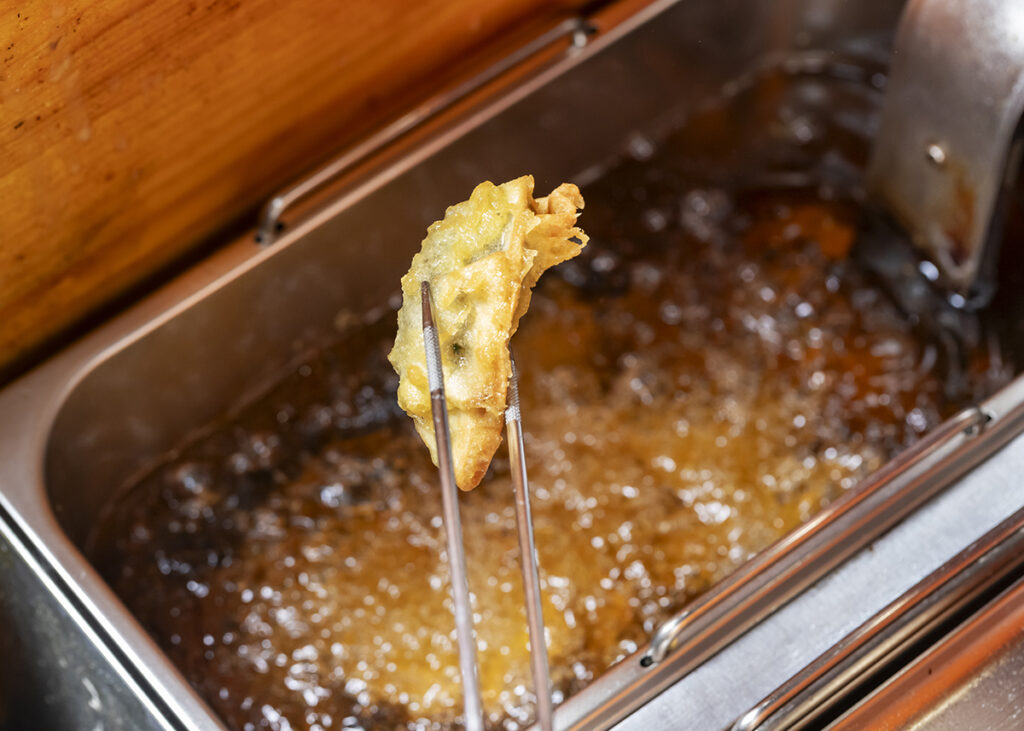 石川県七尾市の居酒屋「朝漁れ一番哲」の牡蠣餃子を揚げているところ